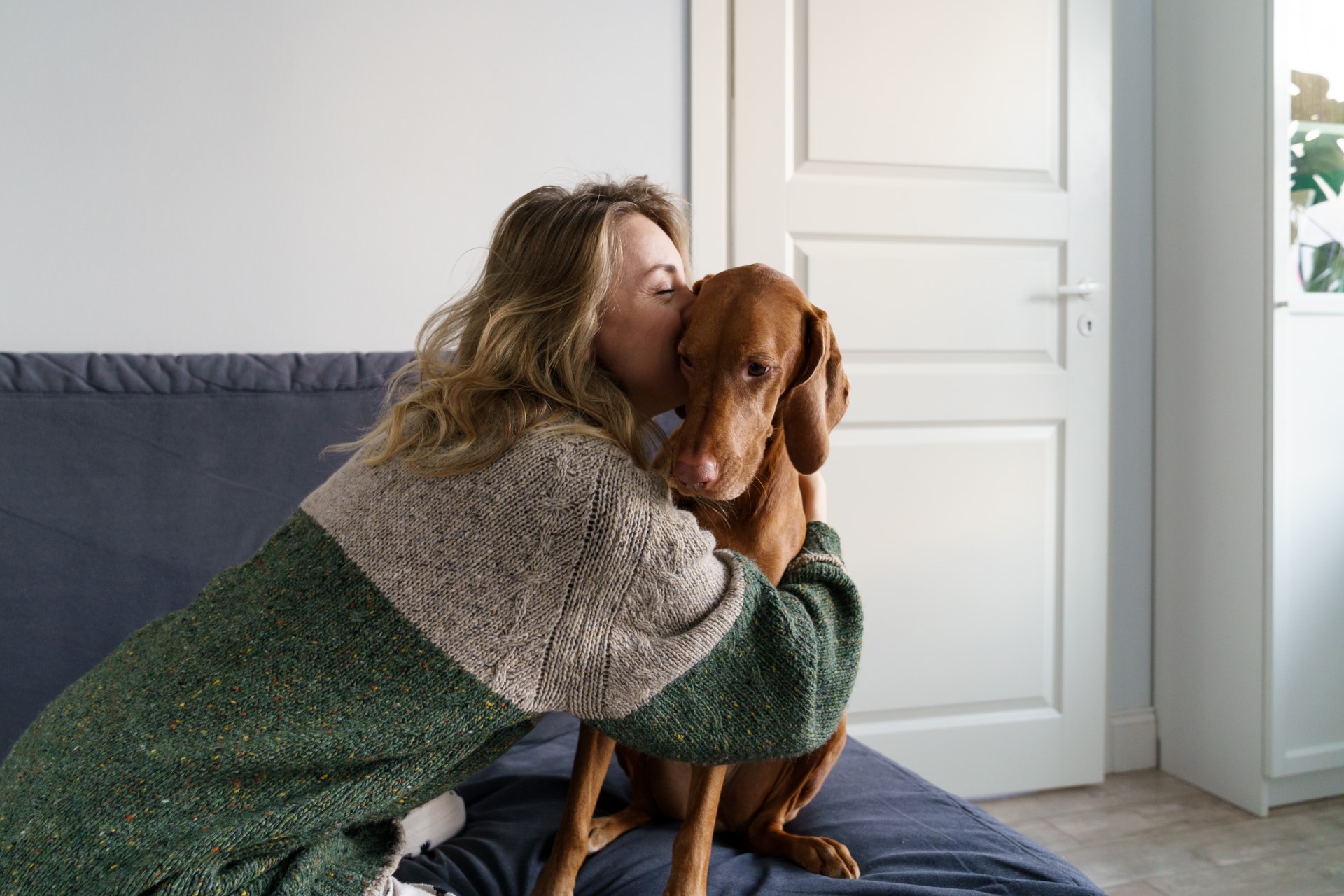 A woman hugging her dog that's safe because of tick prevention.